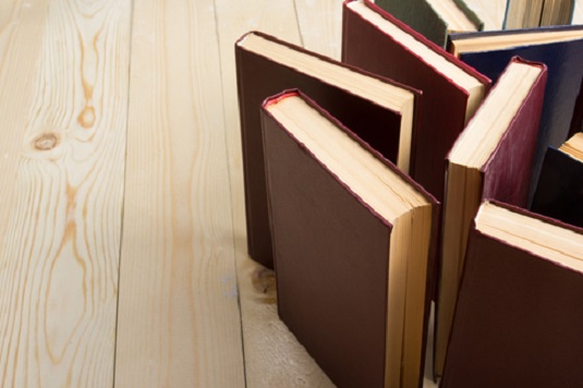 books stacked upright on a wooden floor