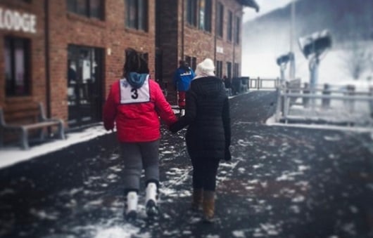 Two girls walking into a ski lodge 