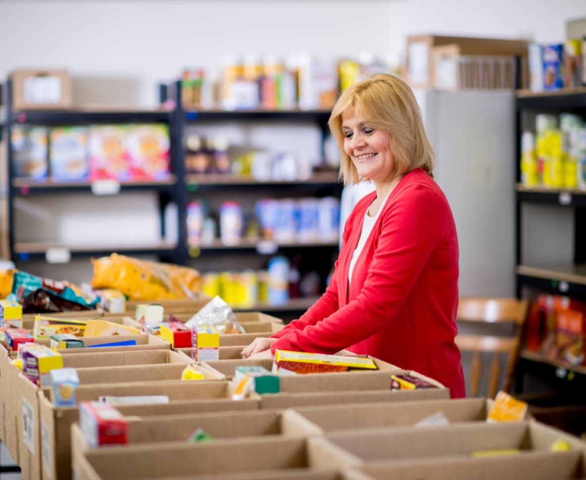 Line of food bank volunteers packing boxes.