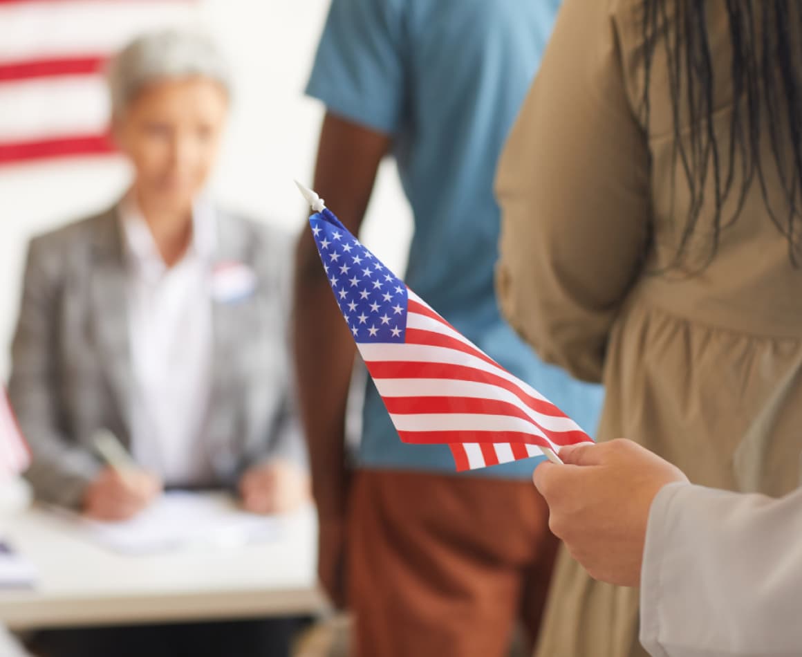 American flag in hand while in line at political campaign. 